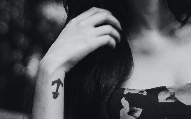 woman's hand with tattoo of anchor on her wrist