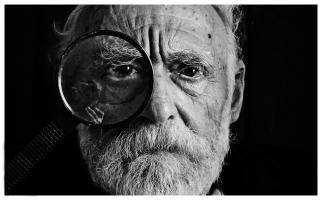 Photo en échelle de gris d'un homme avec une loupe