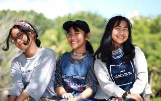 Trois filles souriantes assises l'une à côté de l'autre