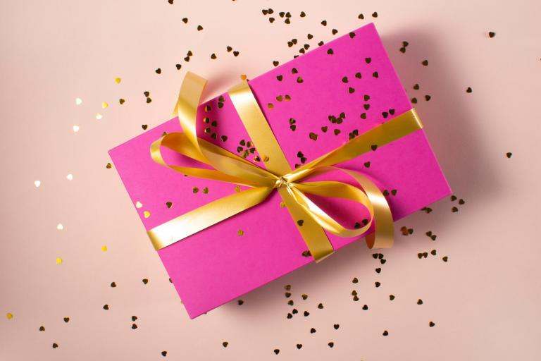 present in pink paper with golden ribbon