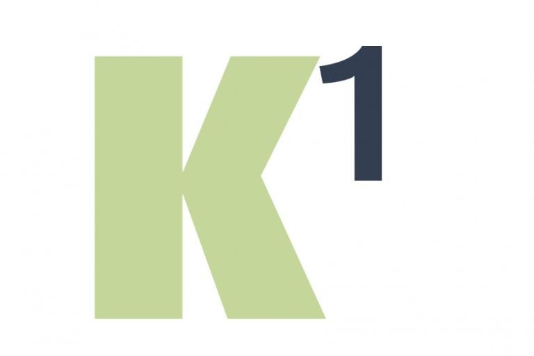 Dikke, lichtgroene, hoofdletter K met een zwart cijfer 1 ernaast, in superscript
