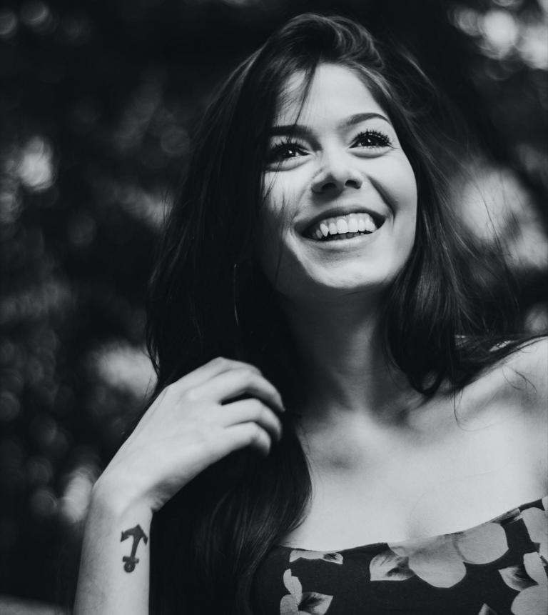 smiling woman with anchor tattoo on her wrist