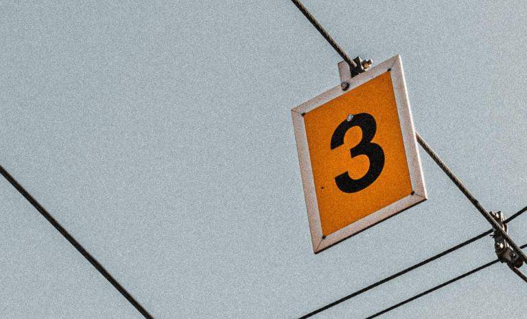 cijfer drie op bordje dat aan kabels hangt